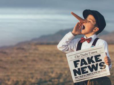 Boy with a long nose holding a newspaper with Fake News as a title